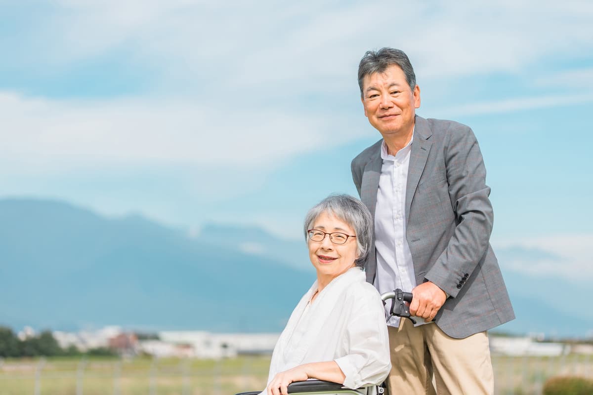青空の下で微笑む年配の夫婦