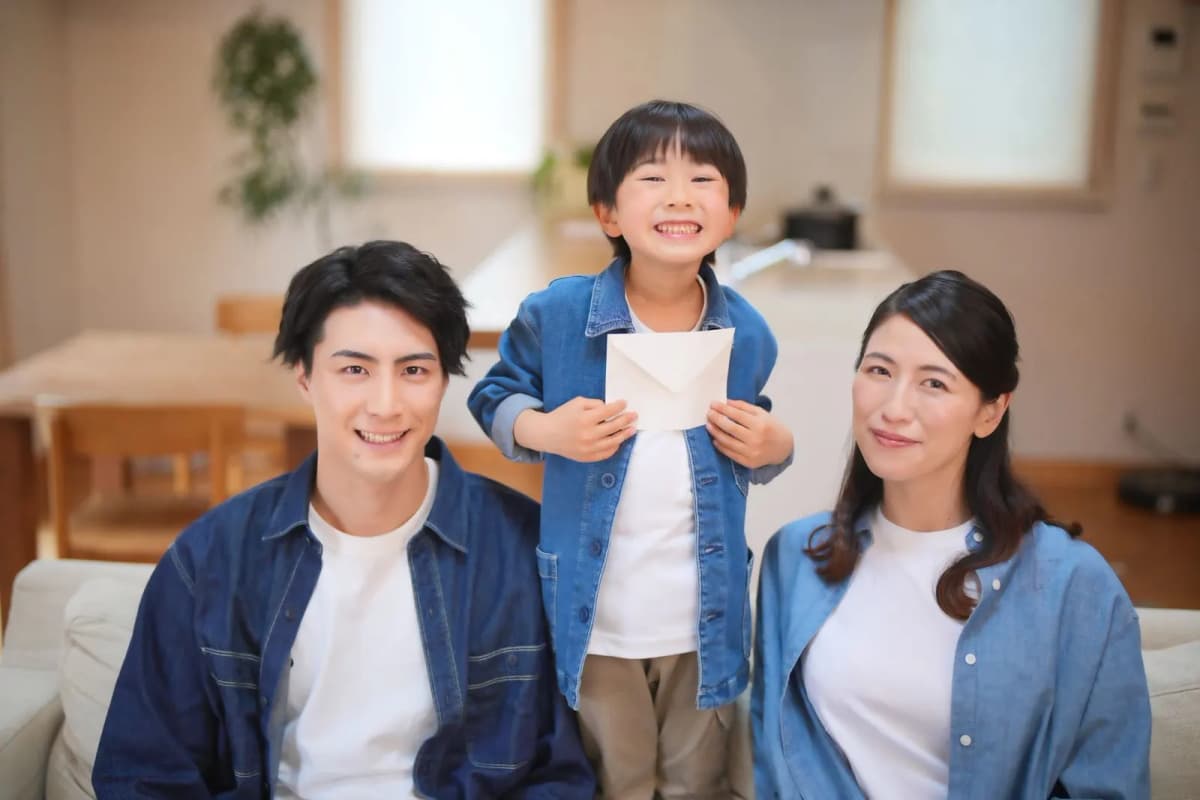 手紙を持って笑顔を見せる親子