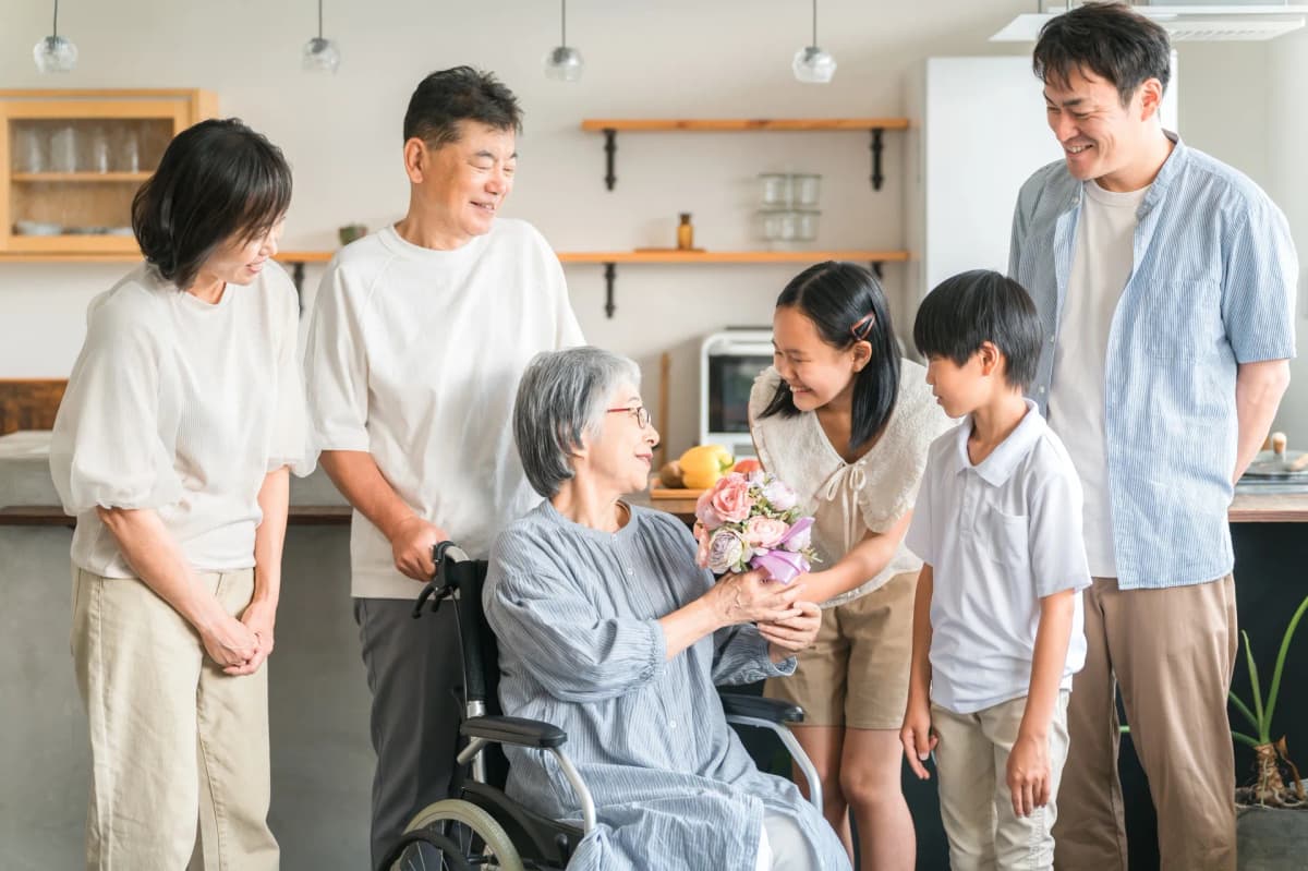 家族から花束を受け取る年配の女性