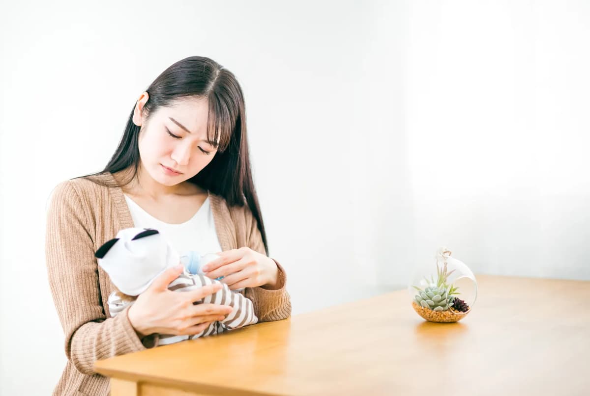 哺乳瓶で赤ちゃんにミルクをあげる母親
