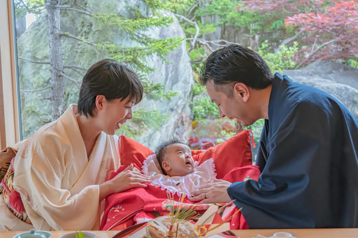 祝い膳を囲む家族と赤ちゃん