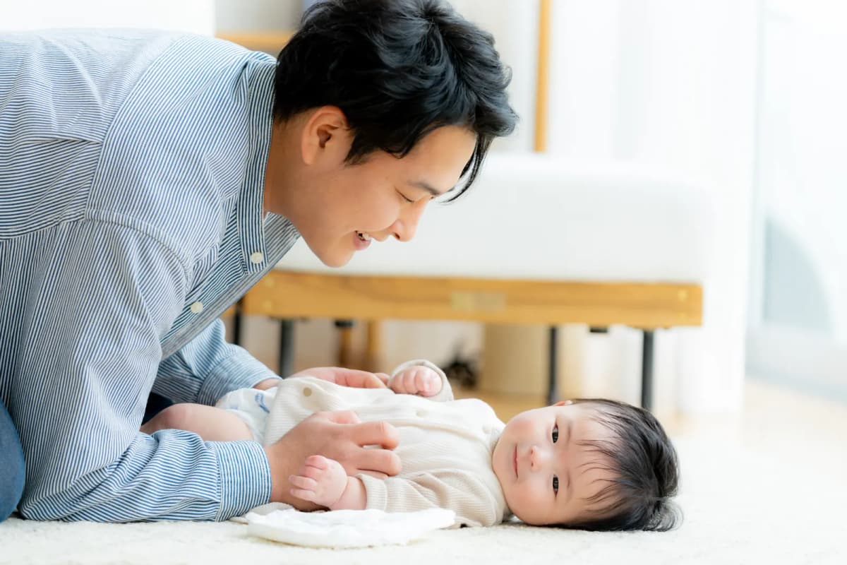 赤ちゃんのおむつを替えるパパ