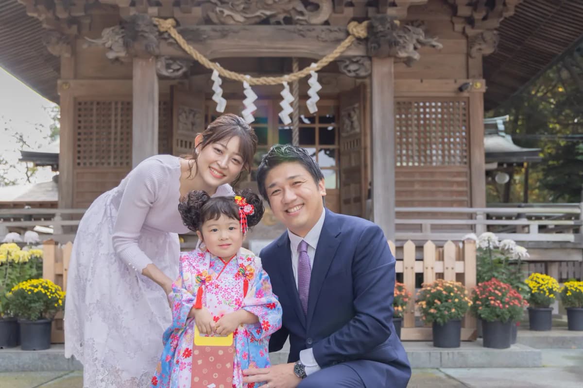 社殿の前で写真を撮る七五三の家族