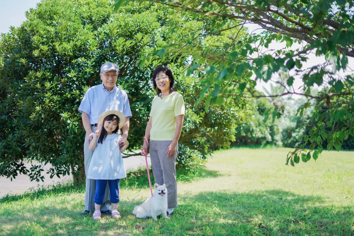 公園で祖父母と並ぶ女の子