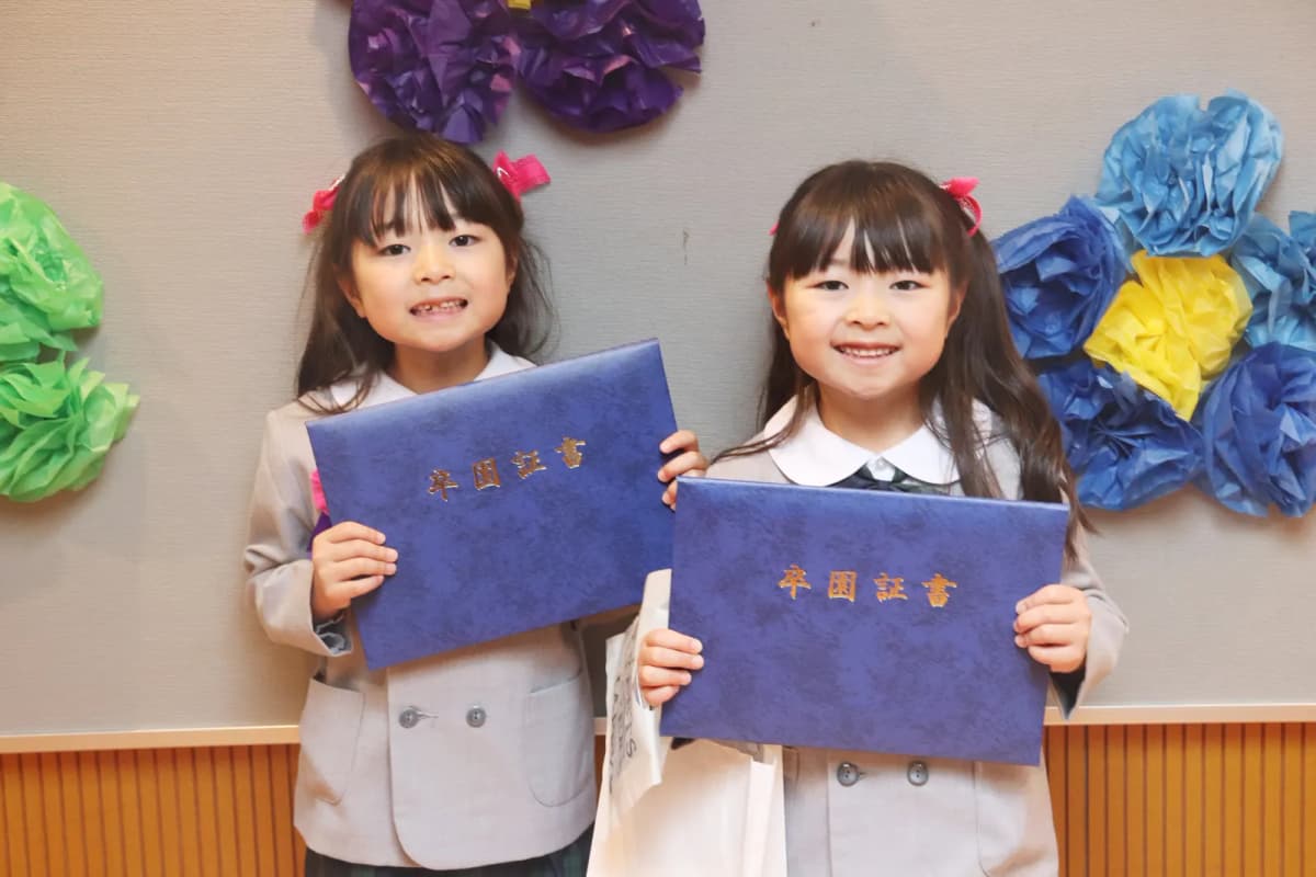 卒園証書を手に並ぶ女の子たち