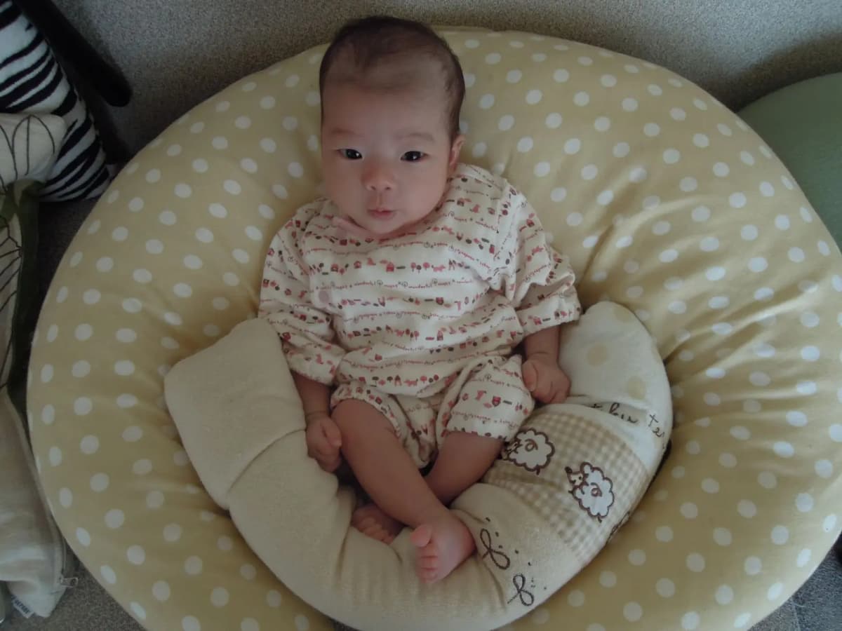 授乳クッションにもたれて座る赤ちゃん