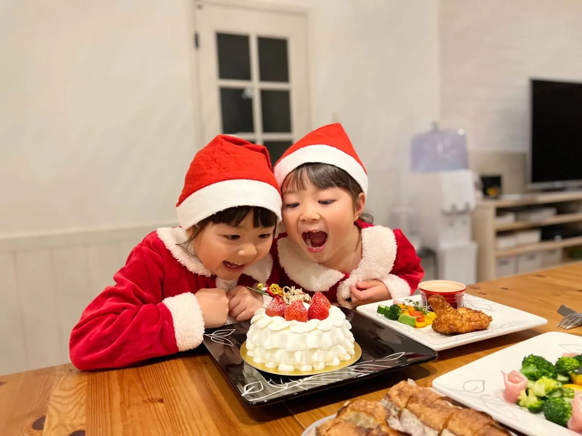 サンタ帽をかぶってケーキを囲む子どもたち
