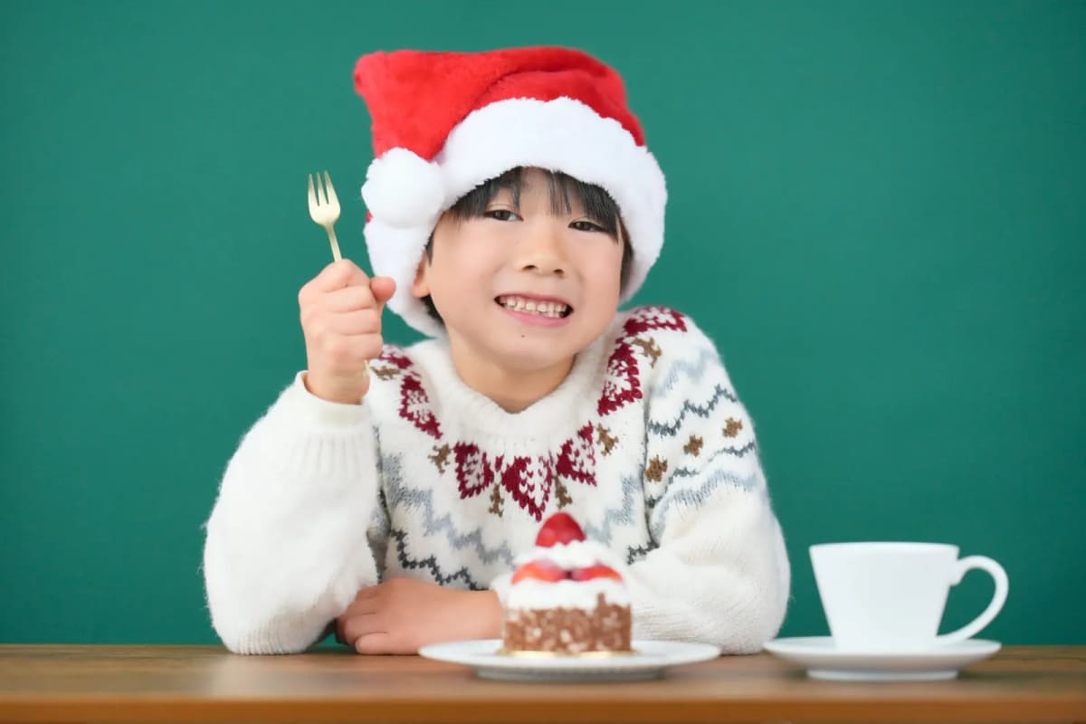 サンタ帽をかぶってケーキを食べる男の子