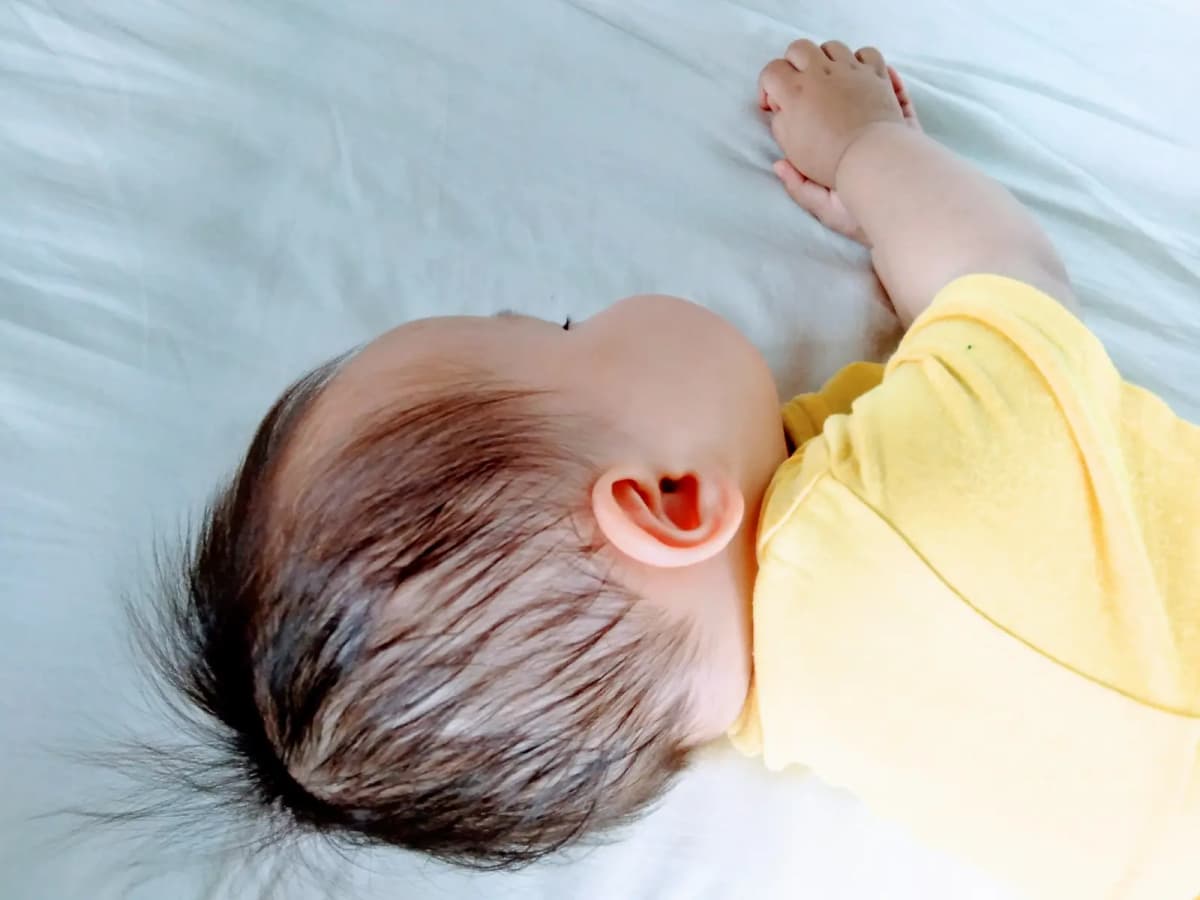 シーツの上で眠る赤ちゃん