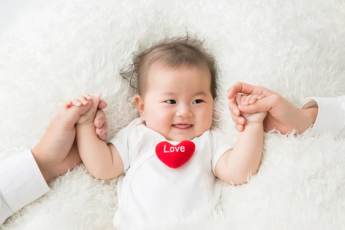 寝転んで笑う生後6か月ごろの赤ちゃん