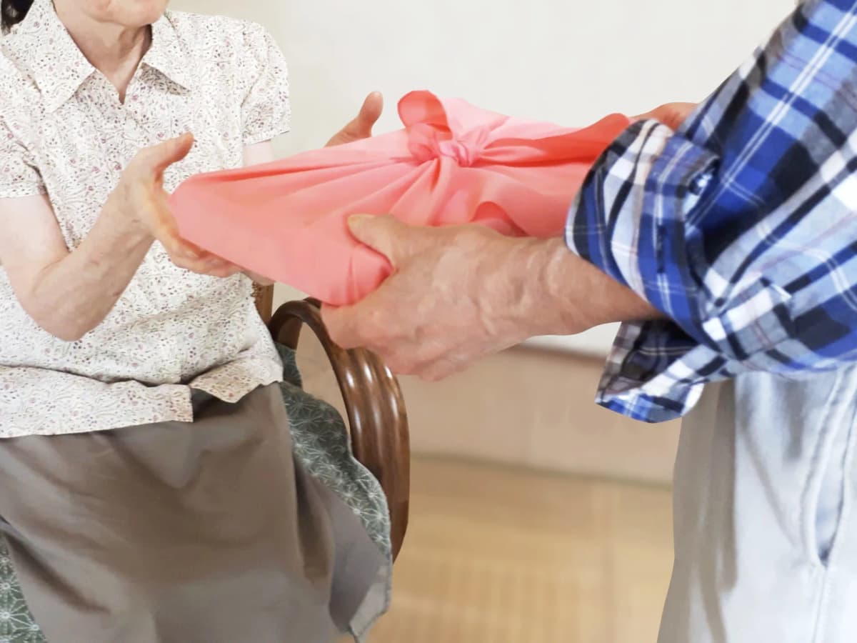 風呂敷に包んだ贈り物を手渡す様子