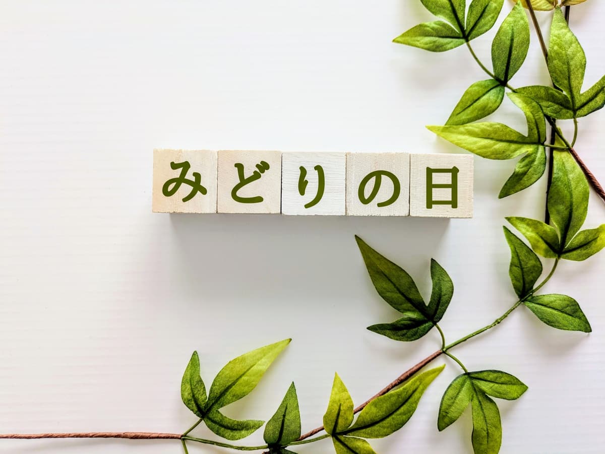 「みどりの日」と書かれた木のブロックと緑の葉