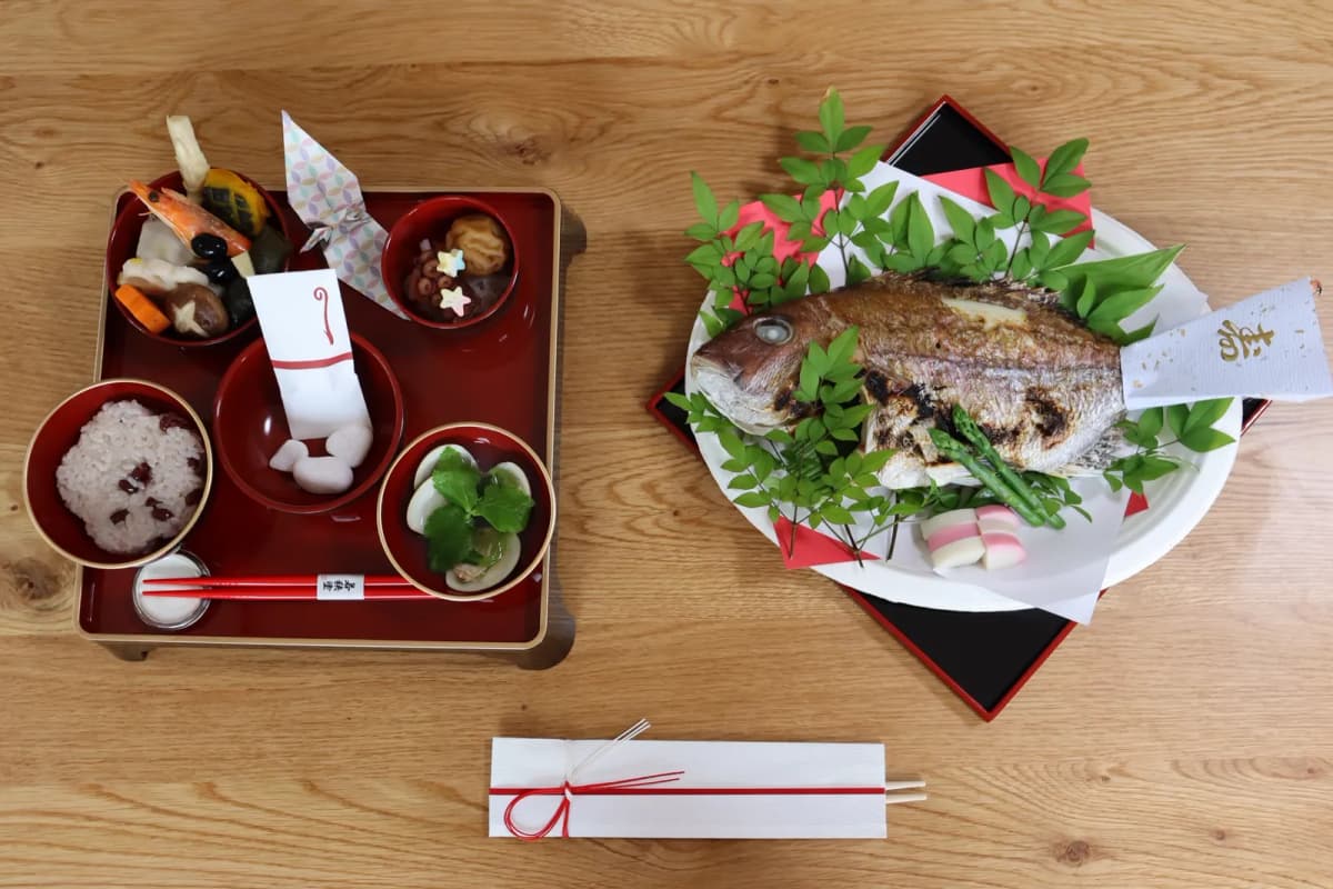 尾頭付きの鯛と赤飯を並べたお食い初めの祝い膳