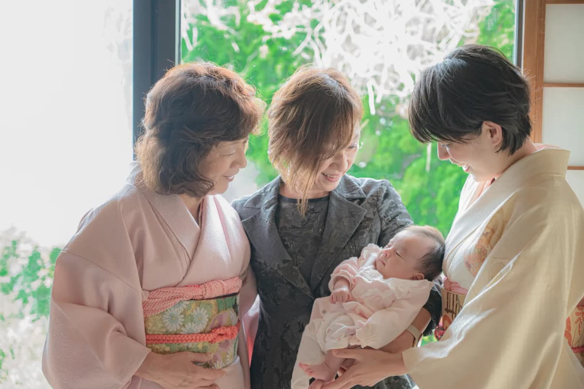 着物姿とスーツ姿の祖母と、赤ちゃんを抱く母親