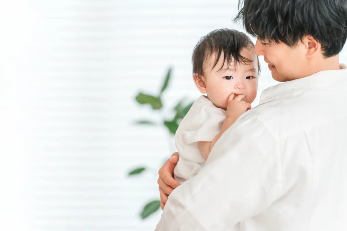 ソファで赤ちゃんを抱っこするパパ