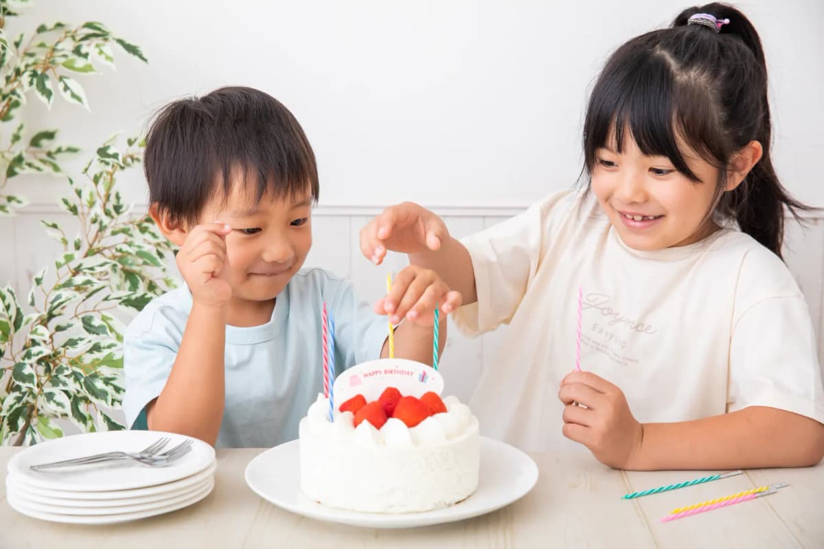 誕生日ケーキを囲むきょうだい