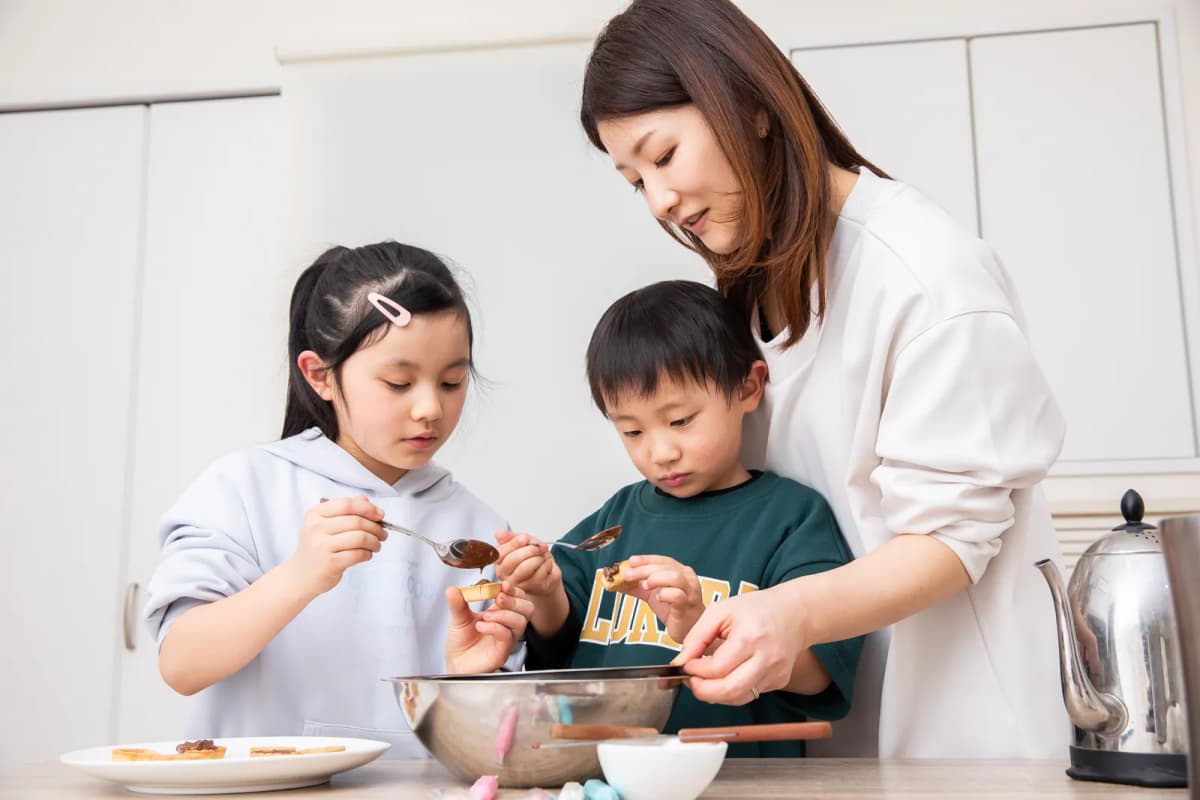 母親と一緒に手作りチョコを作る子どもたち